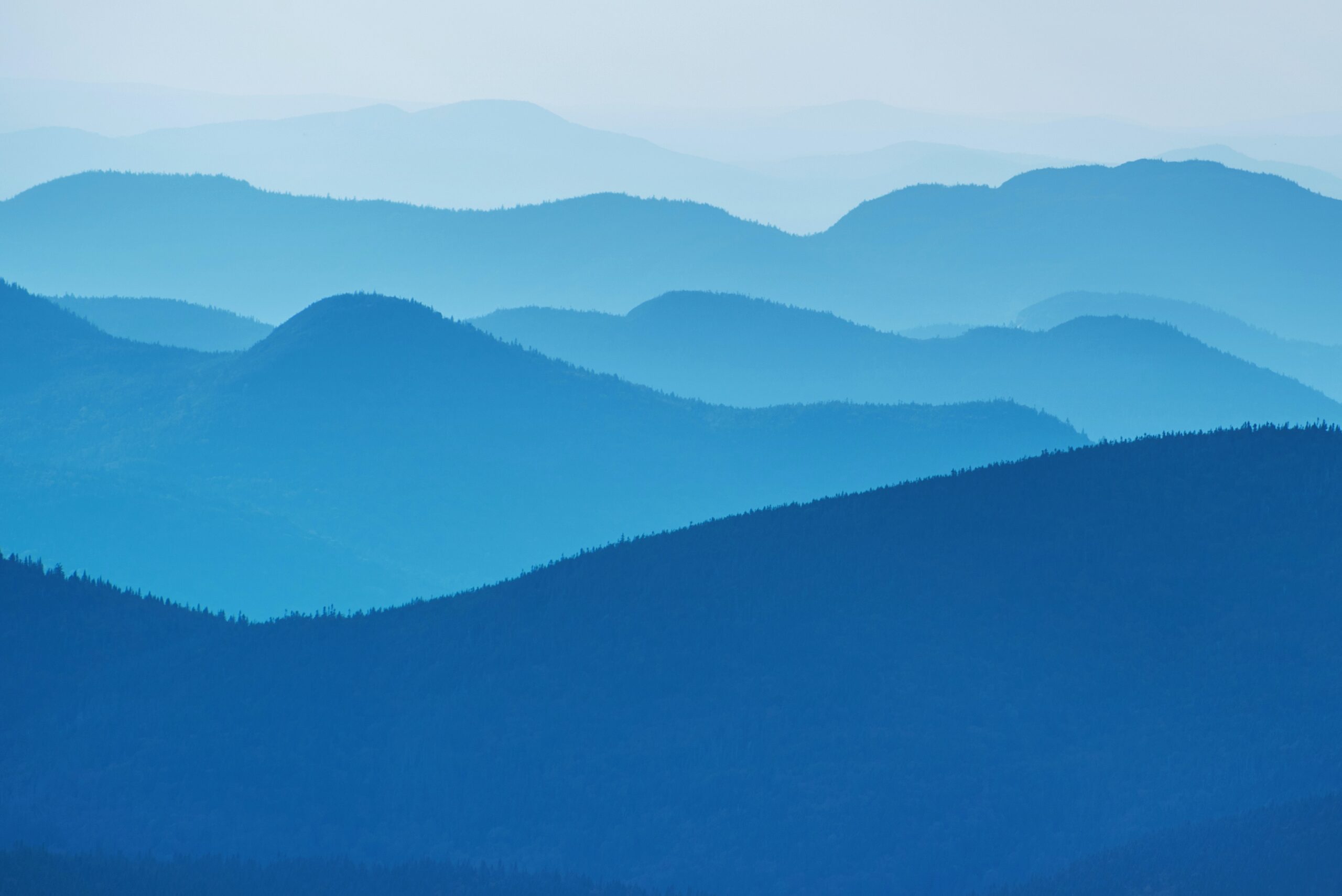 image of layered mountains in blue colours going from dark to light